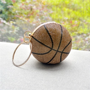 Close-up of golden basketball clutch bag with sparkling rhinestones and metal handle