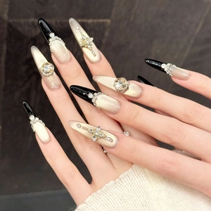Luxurious long black and gold gradient press-on nails with glitter and rhinestones
