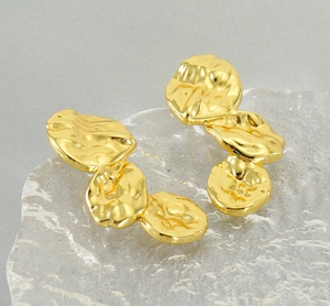 Detailed macro view of golden lava-inspired irregular petal earrings on a ripple base