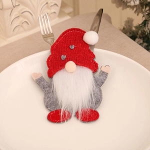 Porte-couverts gnome avec bonnet rouge et feutre gris posé sur une assiette blanche