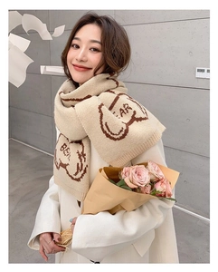 Detail of beige knit scarf featuring cute brown cartoon bears and BEAR text pattern