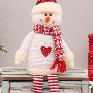 Christmas snowman plush doll with long hanging legs on a vintage wooden box decor