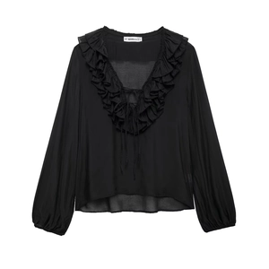 Detail view of the elegant V-neckline with ruffles and drawstring on a black chiffon blouse