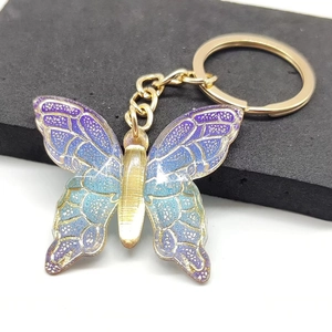 Detailed close-up of a gradient butterfly keychain with shimmering gold metal accents