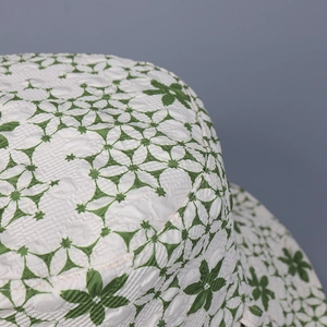 Gros plan d'un chapeau bob réversible en jacquard floral vert avec une texture riche