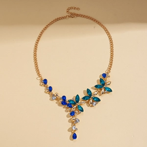 Détail du collier vintage doré avec pendentif floral aux cristaux turquoise et verts