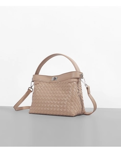Close-up of beige woven texture handbag with metal twist lock and detachable strap