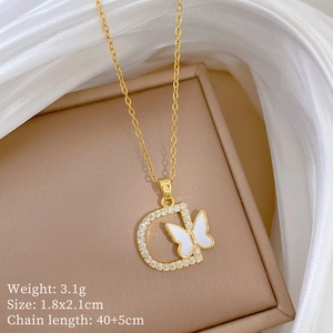 Macro shot of gold D-pendant necklace with butterfly shell and sparkling crystal detail