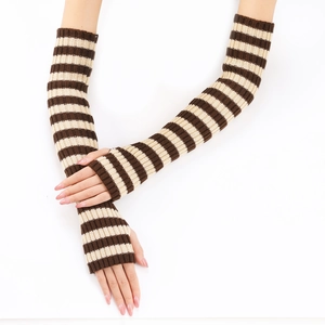 Detail of brown and beige striped knitted arm warmers with a thumb hole for autumn