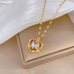 Macro shot of gold heart pendant necklace with micro-pave crystals on silk satin