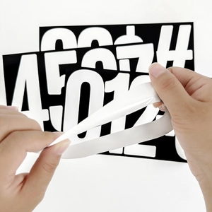 Macro shot showing peeling of waterproof 6-inch vinyl number stickers from backing