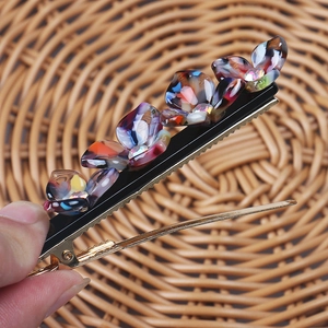 Detailed shot of a floral hair clip featuring colorful resin flowers and small rhinestones