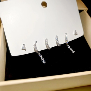 Detailed view of silver zircon geometric earrings set with studs and fringe dangles