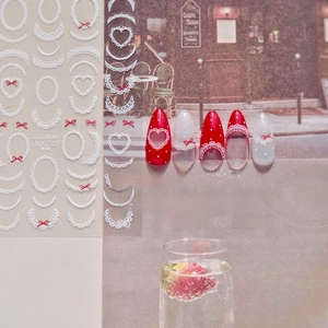 Detailed view of MS 723 nail stickers featuring white lace patterns and red bows