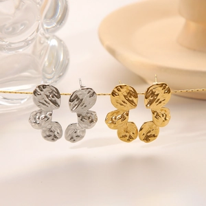 Textured gold and silver drop earrings with hammered metal discs in a minimalist style