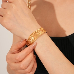 Detail of 18k gold plated mesh cuff bracelet with vintage floral hollow design on wrist