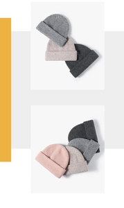 Detail of stacked ribbed knit beanies showing soft wool texture in multiple colors