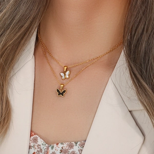 Detail of layered gold butterfly necklace with white mother of pearl and black charms