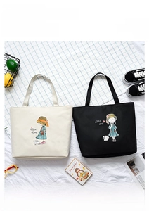 Flat lay of canvas tote bags with cartoon girl prints and zipper closure in a lifestyle setup