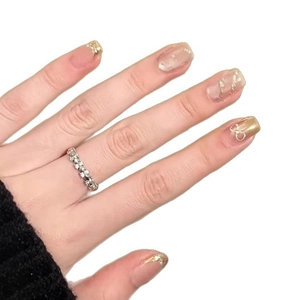 Classic silver floral ring with elegant gold gradient bow press-on nails on hand