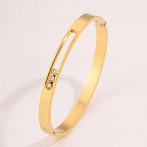 Macro shot of gold titanium bangle featuring sliding diamonds on a classic groove band