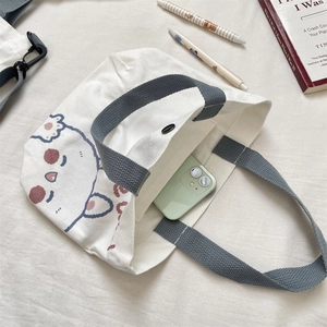 Detail of the magnetic buckle and interior capacity of the cute bear canvas tote bag