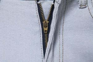 Close-up of durable metal zipper and reinforced double stitching on denim jeans