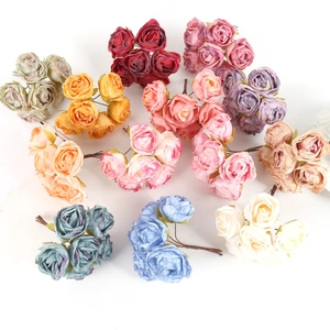 Flat lay of artificial rose bouquets in various colors for DIY decor on white background