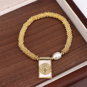 Gold beaded stretch bracelet with shell pearl and religious medallion in a wooden box
