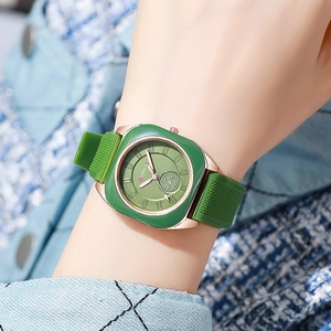 Close-up of square emerald green watch with rose gold case worn on a woman's wrist