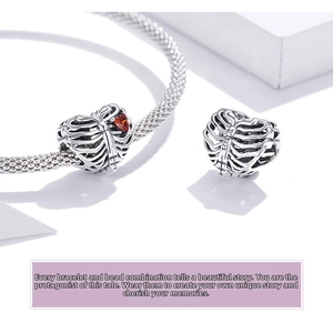 Macro shot of S925 sterling silver skeleton heart charm with a red heart-shaped zircon
