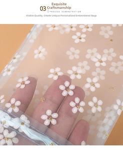 Detailed view of semi-transparent blue organza pouch with white flower embroidery