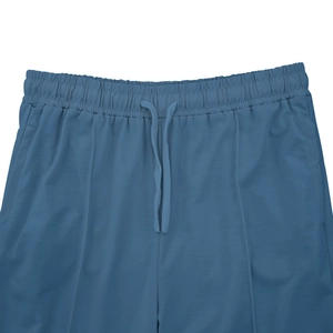 Detailed macro view of the elastic waistband and matching drawstring on blue sports trousers