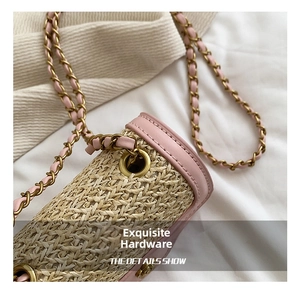 Detail of pink leather trim and golden metal hardware on a straw woven handbag