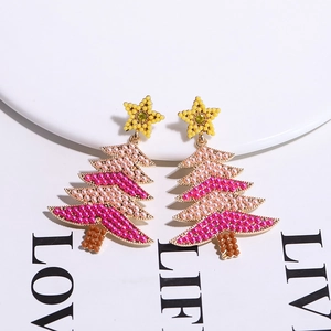 Detail shot of Christmas tree earrings with pink beads and star charms on white background