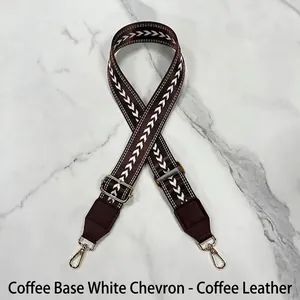 Detail of adjustable coffee bag strap with white arrow pattern and gold metal hooks