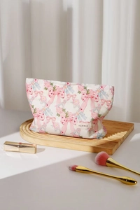 Close-up of pink floral and bow pattern on cotton cosmetic bag with H&R label