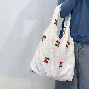 Detail of red cherry embroidery on white faux shearling tote bag for women
