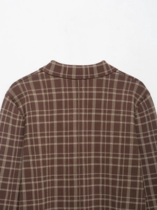 Detail der Stricktextur und Karomuster an der Schulter der braun karierten Jacke