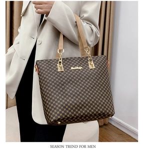 Detail of woman holding a brown tote bag with geometric print and gold metallic hardware