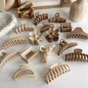 Detailed macro view of earth-toned matte resin hair claws in various elegant shapes