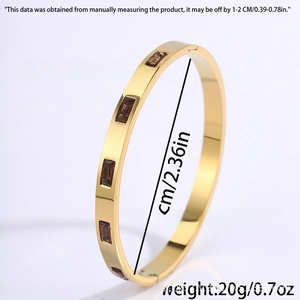 Detail showing 6cm diameter and 20g weight of golden bangle with square brown zircon