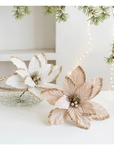 Detail of velvet cream and pink poinsettia flowers with gold glitter on a festive shelf