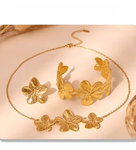 Detailed close-up of PVD gold plated flower jewelry set featuring necklace and earrings