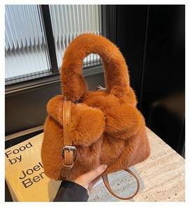 Close-up of caramel plush bucket bag with soft faux fur texture and leather strap