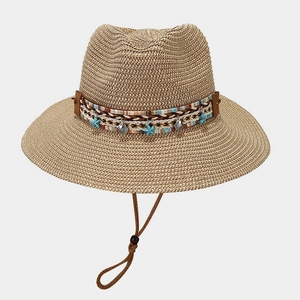 Detail of straw sun hat with starfish pendant and shell charms on decorative band
