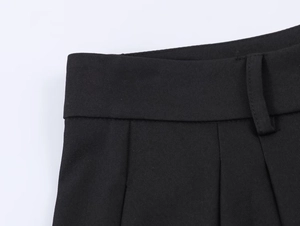 Detailed macro view of black suit trousers waistline showing fine twill texture and belt loops