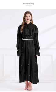Détail d'une robe plissée de luxe avec dentelle, paillettes et ceinture de perles