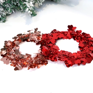 Close-up of heart-shaped tinsel wreaths in shiny red and rose gold for festive decoration