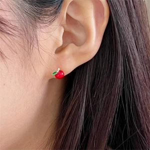 Minimalist 925 silver red apple stud earrings worn on ear with vibrant enamel finish